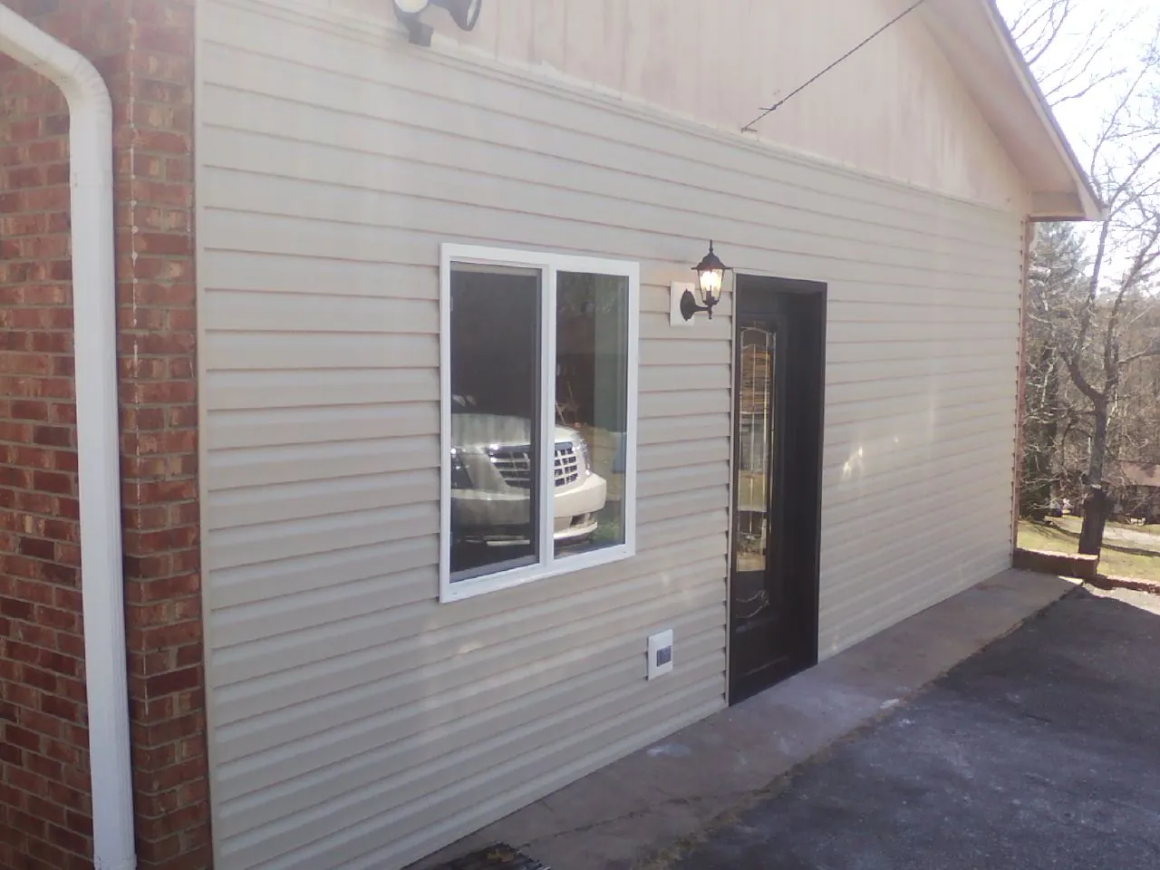 New vinyl siding and entry door on a room addition in Monument Beach