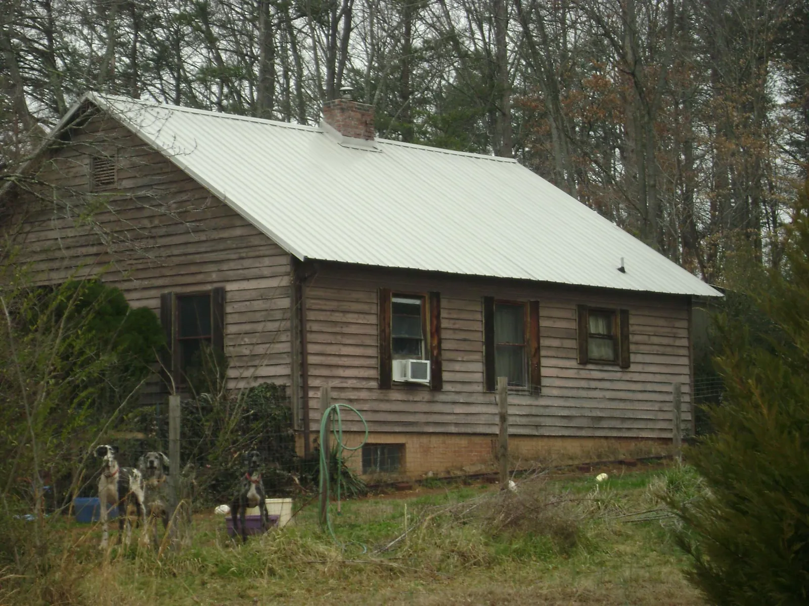 White metal roof on an old wood sided farmhouse, from a Metal Roof Installation job in Monument Beach